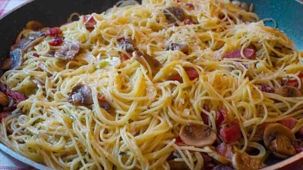 Spaghettis aux champignons aux tomates et aux lardons: un plat riche et